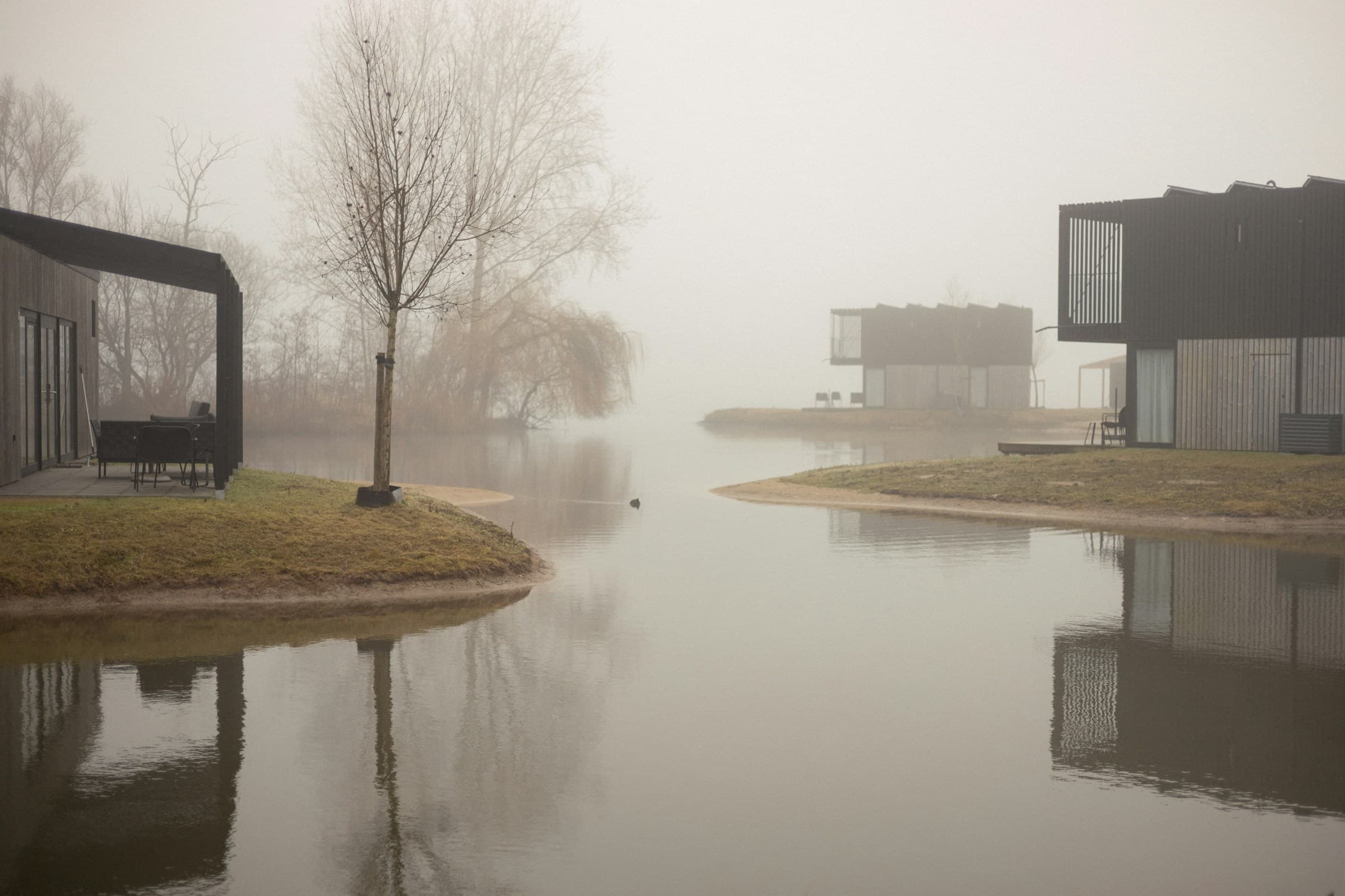 Moderne woningen aan een meer als illustratief sfeerbeeld bij een installatie met zoneregeling