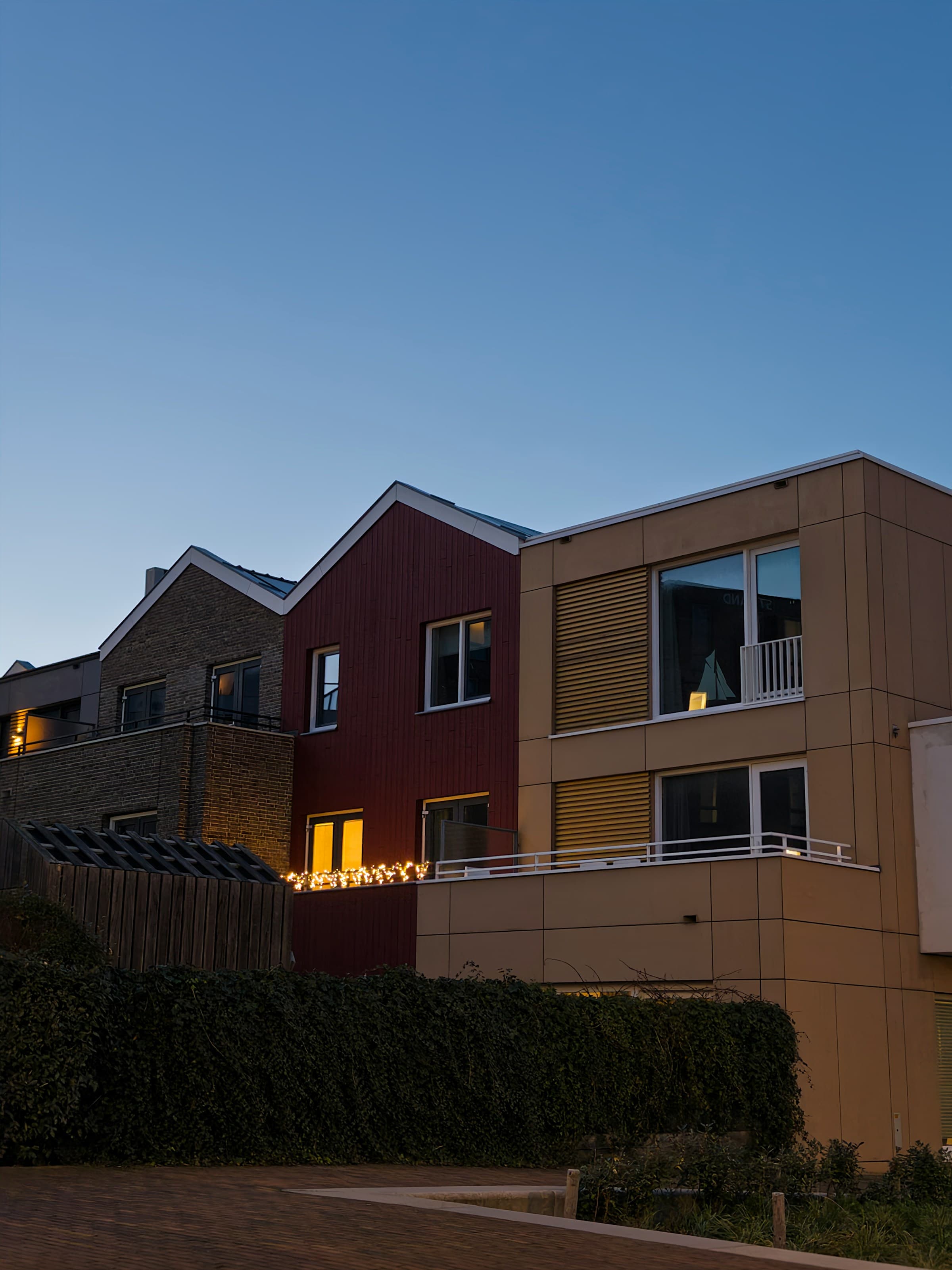 Moderne woningen bij avondlicht als illustratief sfeerbeeld bij een lucht-waterinstallatie