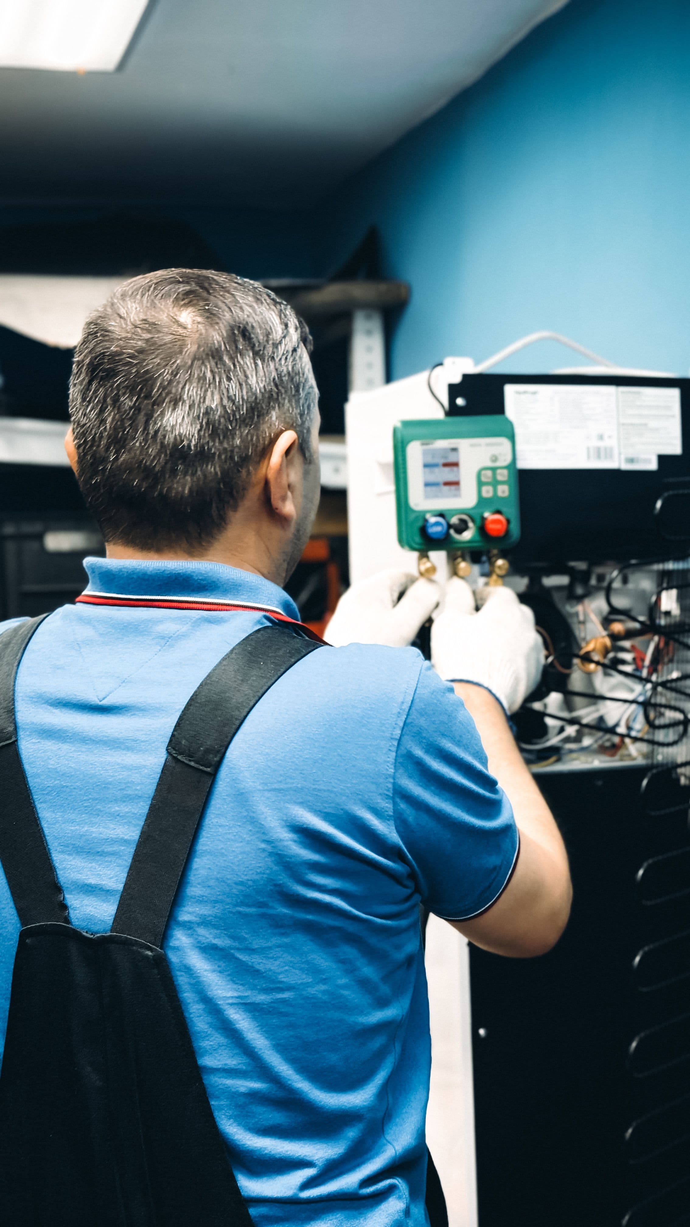 Monteur voert diagnostiek uit aan technische apparatuur; illustratief stockbeeld